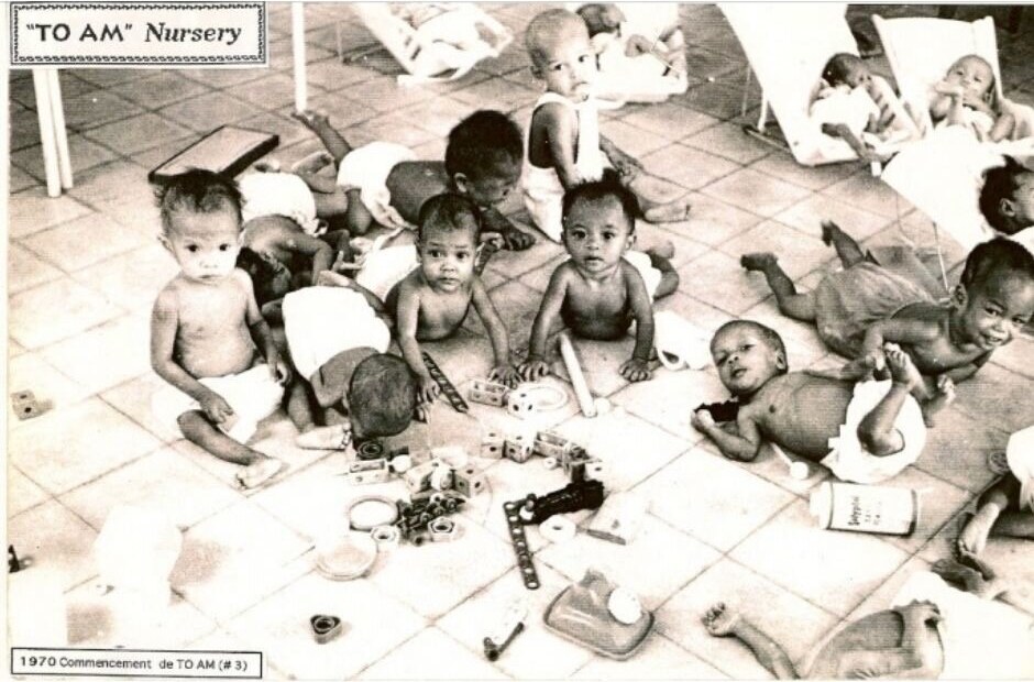 Infants on a tiled floor with toys in the To Am Nursery, from the Friends For All Children Collection